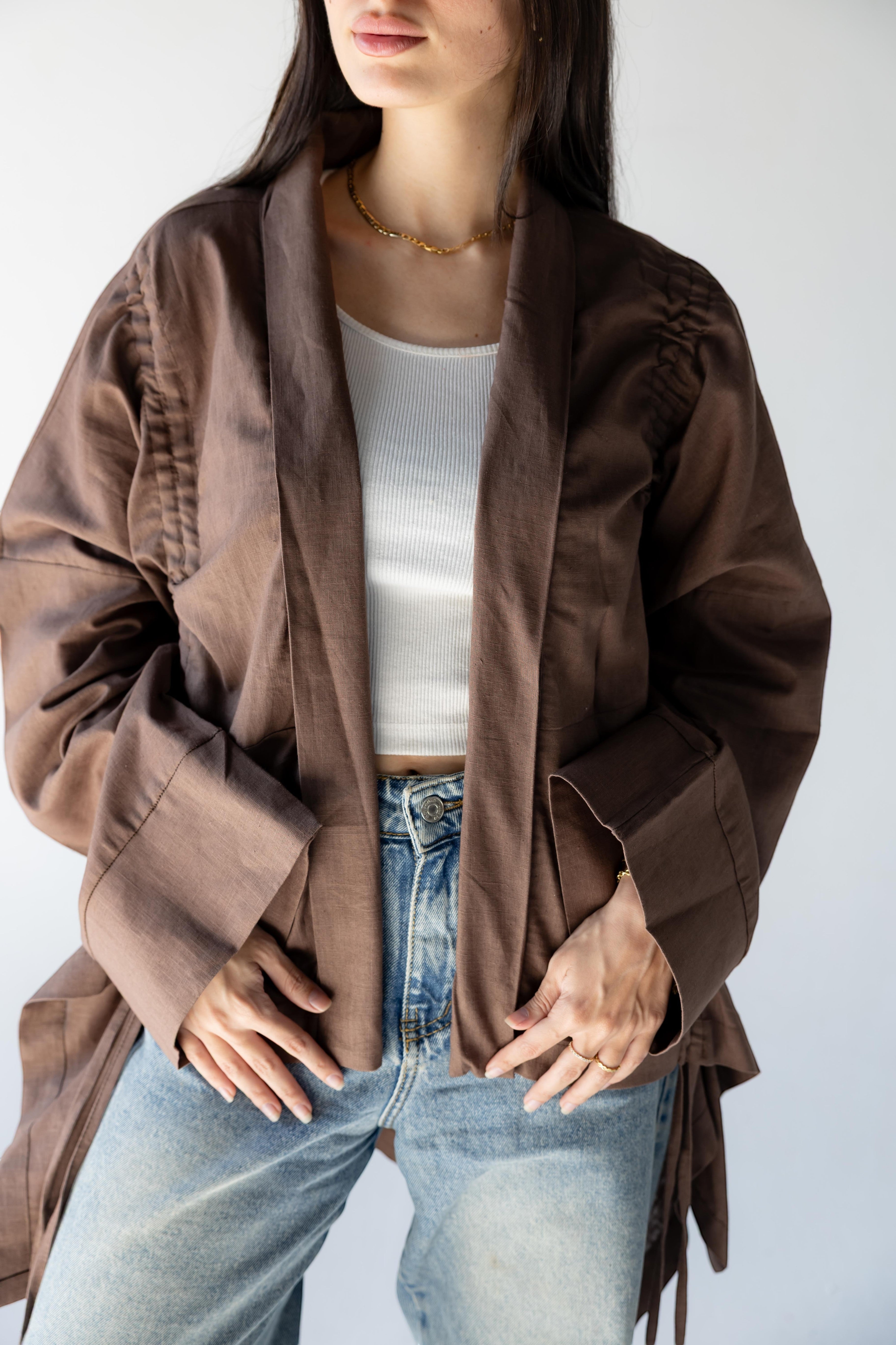 ZONA brown 100% linen kimono jacket with statement sleeves and flowing details, worn over a white tank and jeans.